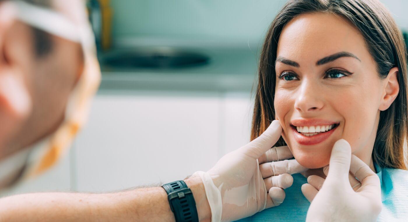 Woman in dental chair smiling at her cosmetic dentist in Arlington