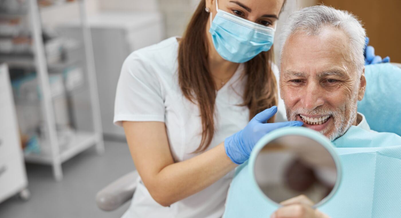 Senior man admiring his new smile with dental implants in Arlington