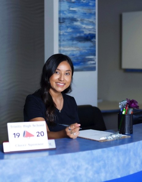 Dental team member smiling at front desk