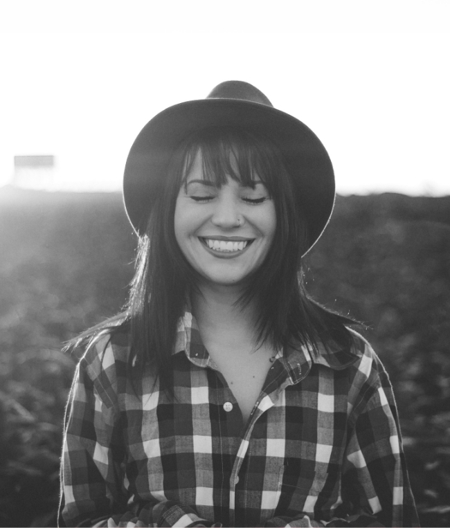 Woman in plaid shirt smiling outdoors after visiting Arlington dentist