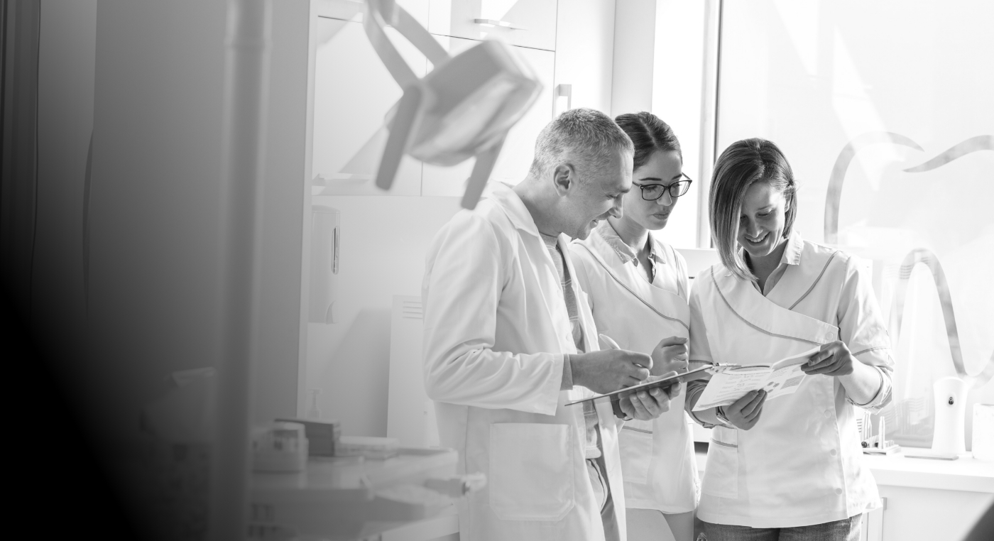 Four dental team members looking at papers together