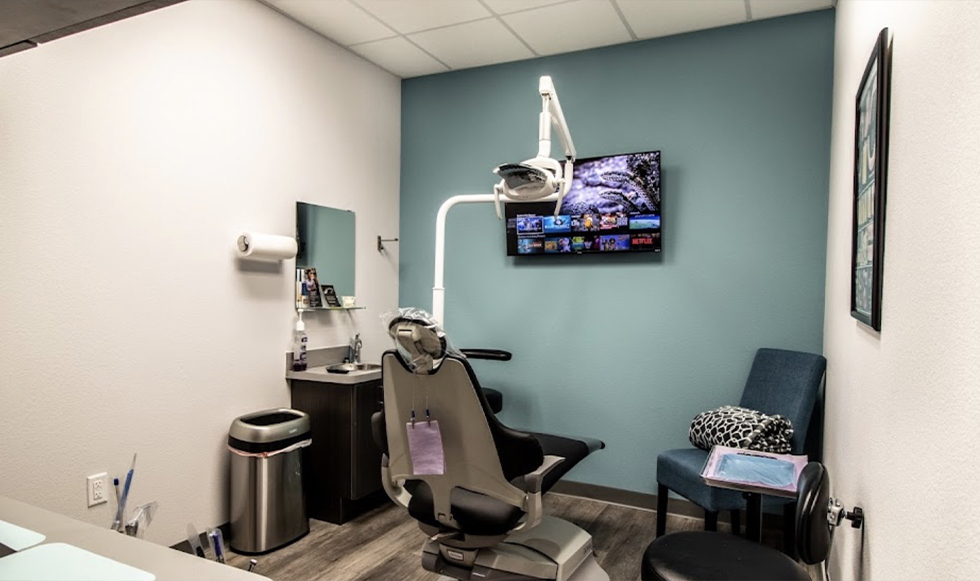 Dental treatment room with a T V on the wall