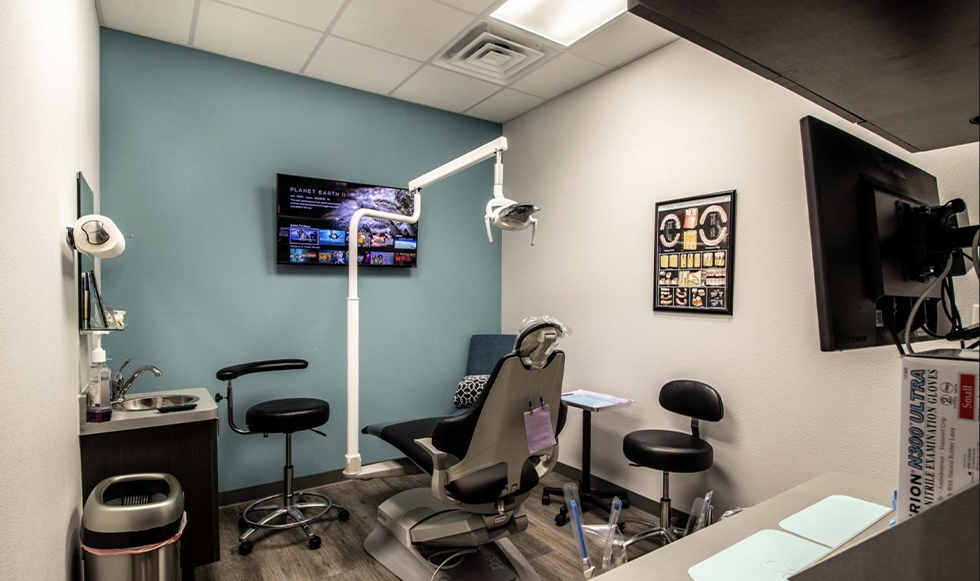 Dental exam room with a T V on the wall