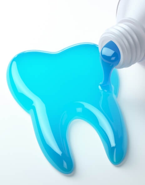 Blue toothpaste spilling out of tube into shape of tooth