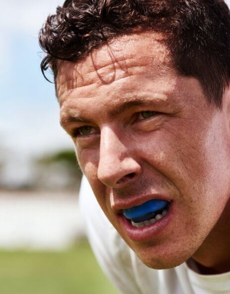 Football player with blue athletic mouthguard over his teeth