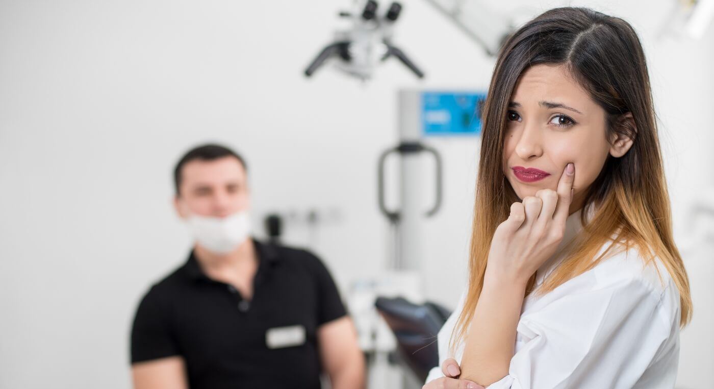 Woman touching her cheek in pain before root canal treatment in Arlington