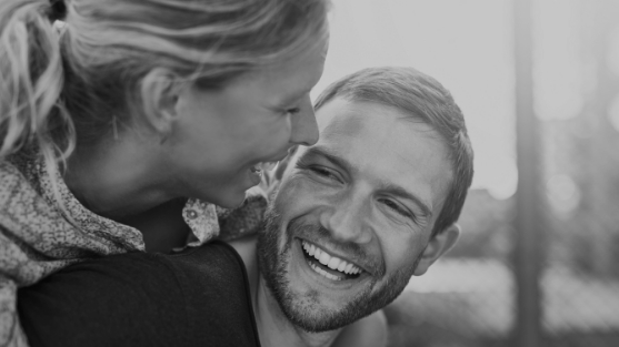Smiling woman hugging man from behind