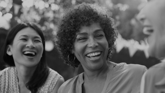 Three women laughing together outdoors