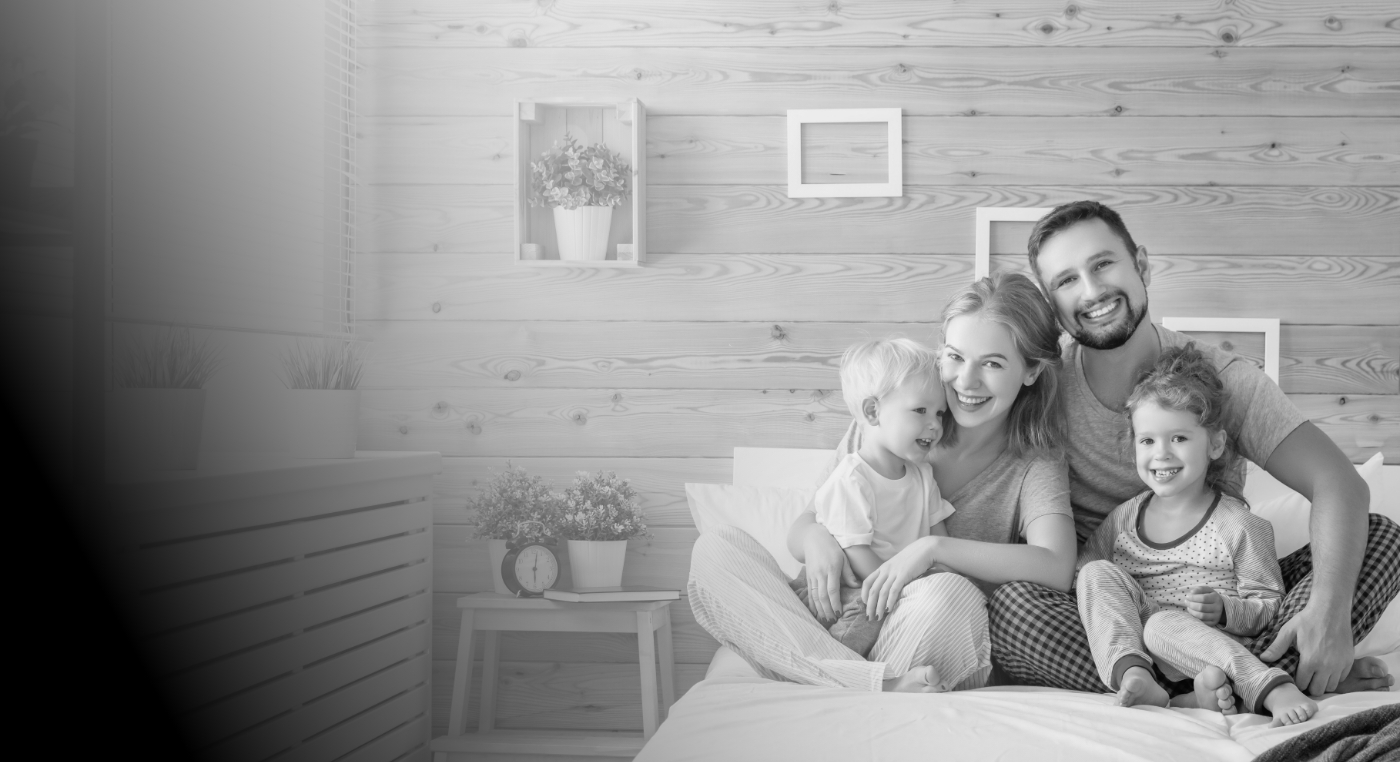 Family of four sitting on bed after dental services in Arlington