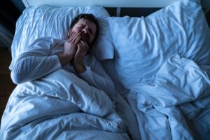 Man in bed who has a toothache